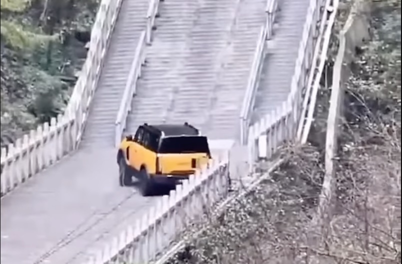 A YouTube screenshot of an SUV sliding backwards into some railings