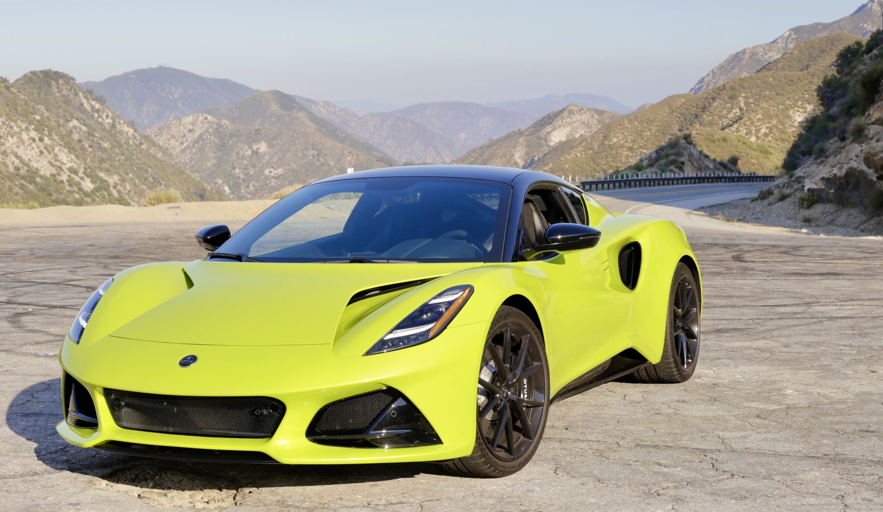 A lime green Lotus Emira at a highway lookout